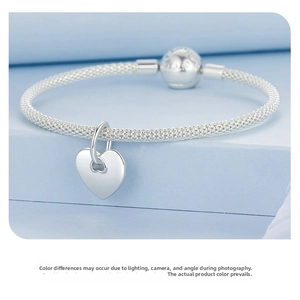 Close-up of S925 sterling silver mesh bracelet with a polished heart pendant on a stand