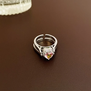 Close-up of heart-shaped pink and yellow zircon ring on a textured leather background