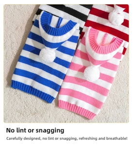 Detailed flat lay of striped knit pet hoodies with decorative pom-poms and ribbed hems