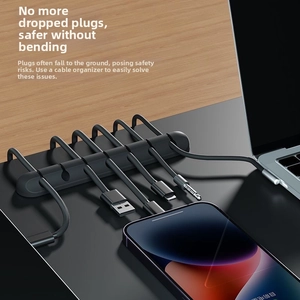 Detail view of black 5-slot silicone cable organizer securing USB wires on a wooden desk