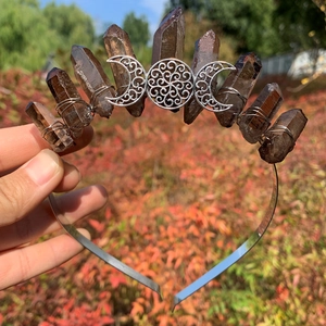 Detail of handmade crown with smoky quartz crystals and silver triple moon goddess symbol