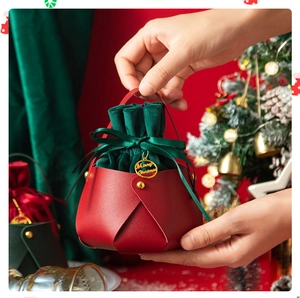 Detail of red PU leather Christmas gift bag with green velvet pouch and gold hardware