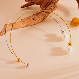 Détail de colliers ouverts en or et argent avec perles et sphères métalliques élégantes