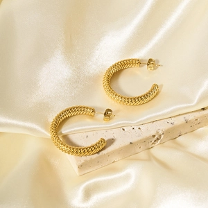 Minimalist 18k gold plated stainless steel twisted hoop earrings on textured stone