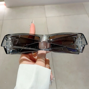 Detail view of foldable futuristic rectangle sunglasses with dark grey frames and brown lenses