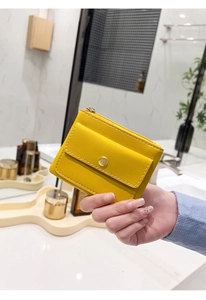Macro shot of yellow PU leather mini purse with functional snap and zipper detail