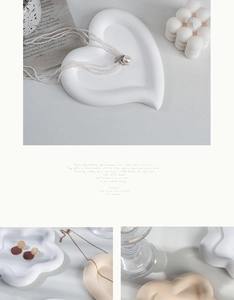 Macro view of heart and flower ceramic jewelry trays with pearl necklace and soft lighting