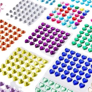 Close-up of assorted colorful heart-shaped acrylic face gems for festival makeup