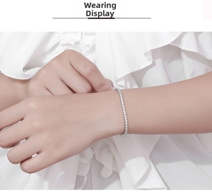 Close-up of 2.5mm moissanite tennis bracelet in sterling silver worn on a woman's wrist