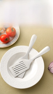 Detail of 304 stainless steel spatula set with SUS 304 engraving on a white plate