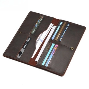 Detail view of the deep brown leather long wallet interior with card slots and metal snap