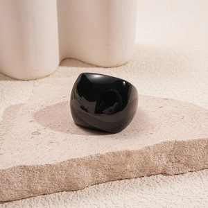 Detailed view of the wide black resin square ring displayed on a stone plinth