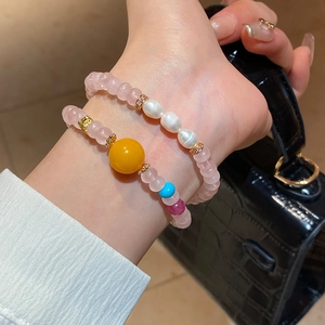 Détail de bracelets en perles de cristal rose avec perles et ambre sur poignet avec sac noir
