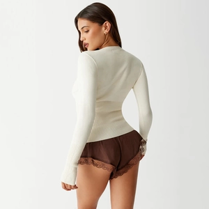 Detailed back view of cream slim fit knit sweater with ribbed cuffs and lace shorts