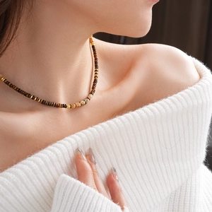 Close-up of square tiger eye beaded necklace on model with vintage golden accents