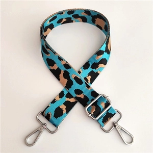 Macro shot of colorful leopard print bag strap with polished silver metal lobster clasps