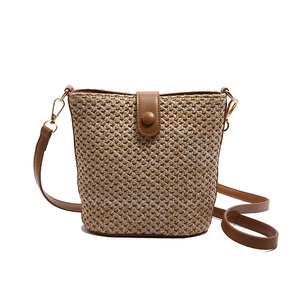 Woven straw bucket bag with brown PU leather flap and adjustable strap for summer beach vacation