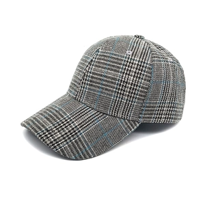 Detailed view of the vintage houndstooth plaid fabric and curved brim on this baseball cap