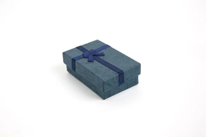 Detail of dark blue jewelry gift box featuring textured finish and matching silk ribbon bow