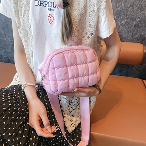 Close-up of pink quilted crossbody waist bag with diamond pattern and wide strap