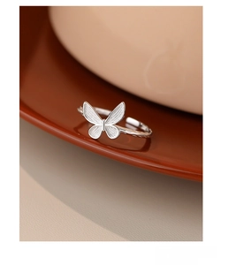Macro detail of S925 silver butterfly ring with brushed texture on the delicate wings