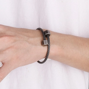 Macro detail of industrial style braided steel cable bracelet with hexagonal nuts