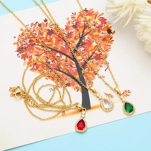 Detail of teardrop zircon pendants in red, emerald, and clear colors on gold chains
