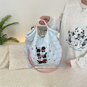 Detail of light blue quilted tote bag with cute black cat embroidery and colorful straps