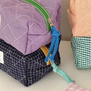 Gesteppte Kosmetiktasche mit Karomuster, bunten Reißverschlüssen und Seilzügen in vielen Farben