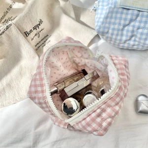 Detail of pink plaid quilted cosmetic bag showing spacious storage for makeup and lipsticks