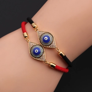 Detail of adjustable evil eye bracelets with blue cubic zirconia on red and black ropes