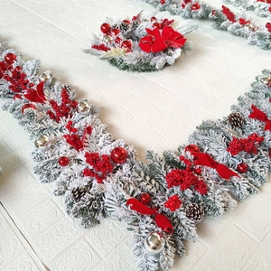 Close-up of frosted Christmas wreath with red berries, pine cones and velvet bows