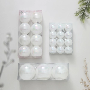 Lot de boules de Noël blanches irisées avec branches de pin et décoration festive