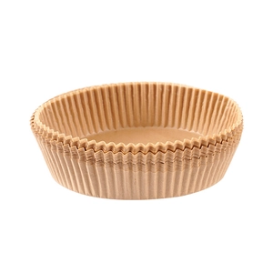 Brown circular air fryer paper liners with wavy edges on white background