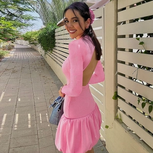 Photo en extérieur de la robe rose en maille côtelée avec dos nu et ourlet à volants