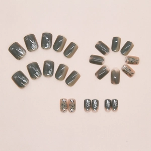 Detailed view of 24pcs dark green gradient press-on nails with silver foil and leaf patterns