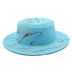 Detailed close-up of colorful paint graffiti texture on a blue straw boater sun hat
