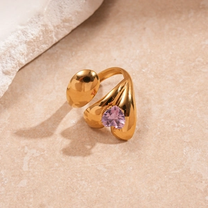 Detailed view of irregular gold stainless steel ring with pink heart zircon and gold bead