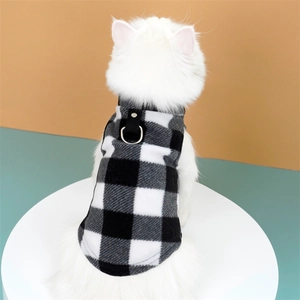 Detail of a black and white checkered pet harness vest with metal D-ring on a cat