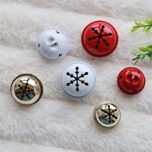 Hollow star and snowflake Christmas bells in red, white and gold on white faux fur