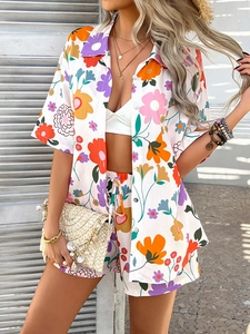 Close-up of vibrant floral print shirt with orange and purple flowers and drawstring shorts