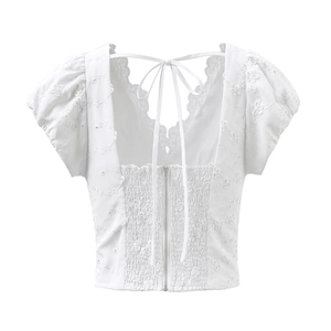 Top corto blanco con mangas abullonadas, bordado floral y cremallera trasera