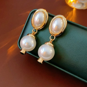 Detailansicht der Vintage Perlenohrringe mit Tigerauge auf einer grünen Schmuckschatulle