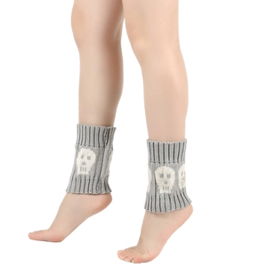 Detailed knit texture of grey skull pattern leg warmers on model for winter styling