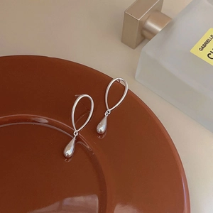 Elegant silver S925 sterling silver teardrop earrings on ceramic plate with a polished finish