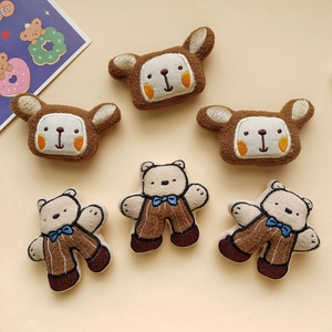 Detailed close-up of cute plush bear pins with embroidery and soft brown textures