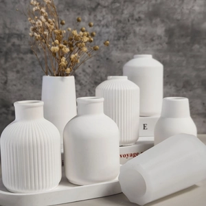Detailed view of white ceramic minimalist vases with vertical ribbed textures and matte finish