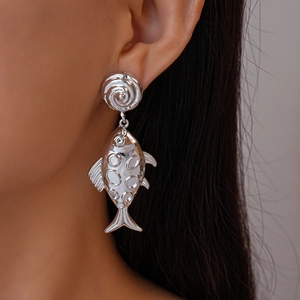 Detailed close-up of a silver textured fish-shaped drop earring worn by a model