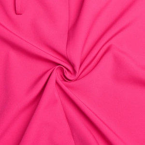 Gros plan sur le tissu du blazer rose vif montrant la texture fine et le drapé soyeux