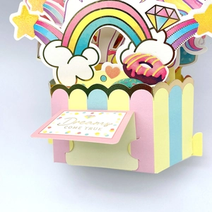 3D pop-up Children's Day card with rainbow, donuts, and Dreams Come True gold foil text